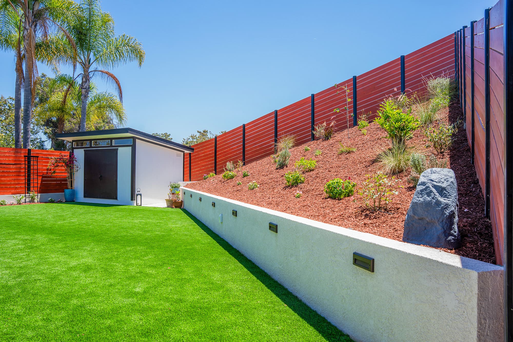 Backyard remodel with artificial turf, retaining wall and landscaping