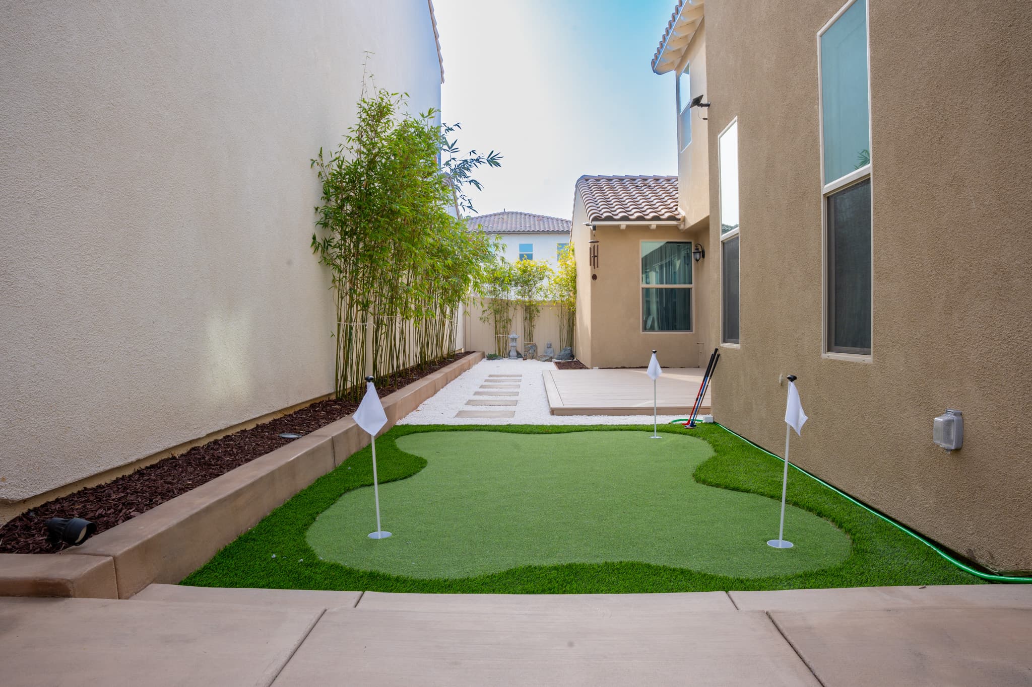 Backyard transformation with a custom putting green and artificial grass.