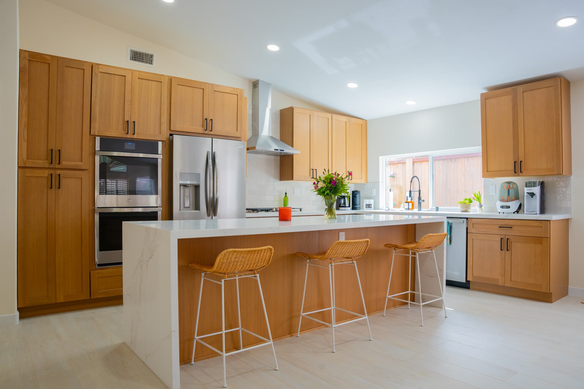 Modern kitchen with custom wood cabinets, stainless steel appliances, and quartz countertops